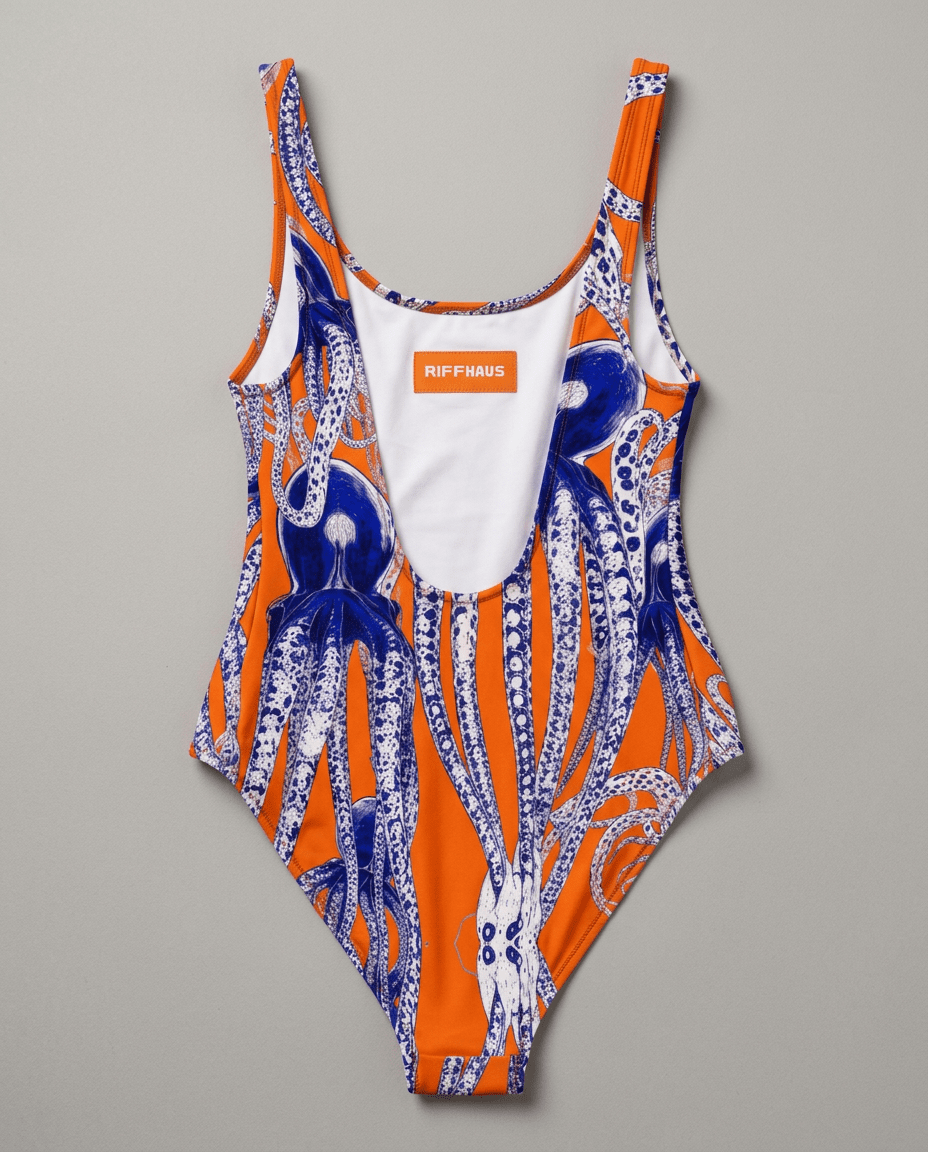 Riffhaus orange octopus swimsuit flat lay showing deep scoop back and brand tag detail