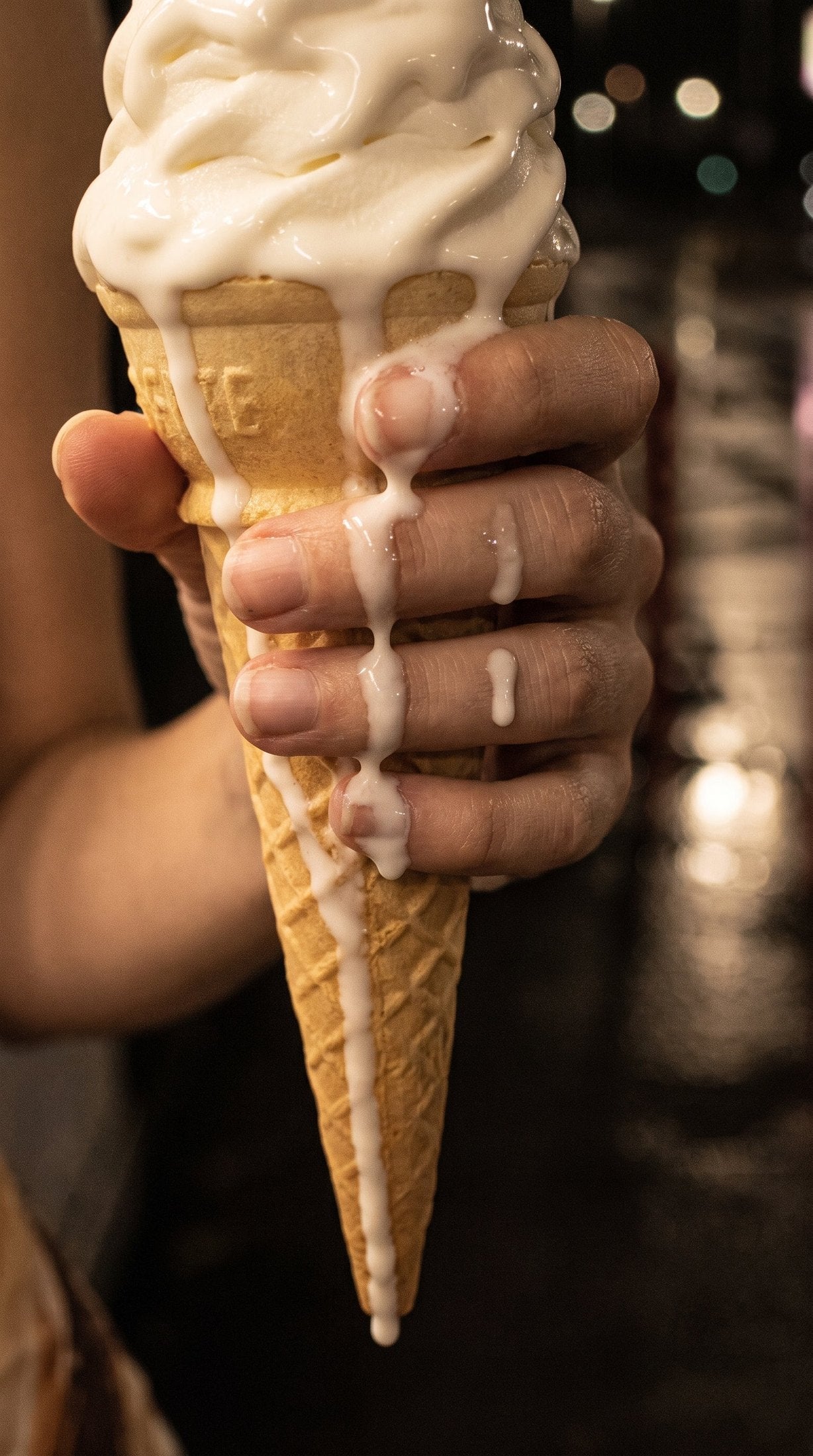 Close-up of melting white soft-serve ice cream in textured waffle cone