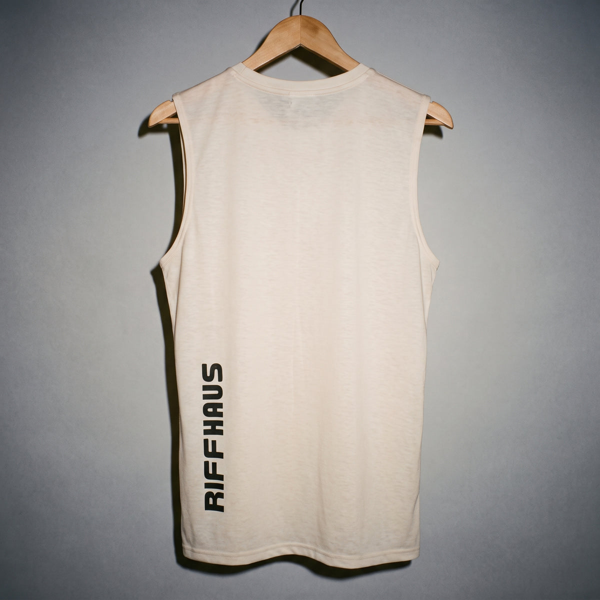 Back view of cream Riffhaus tank top with vertical brand logo print