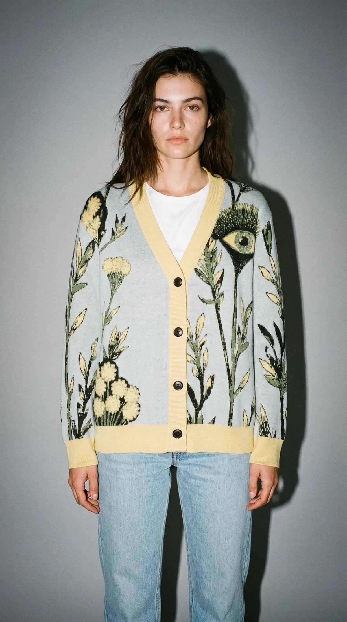 Light blue botanical knit cardigan featuring butter yellow flowers and green grass motifs