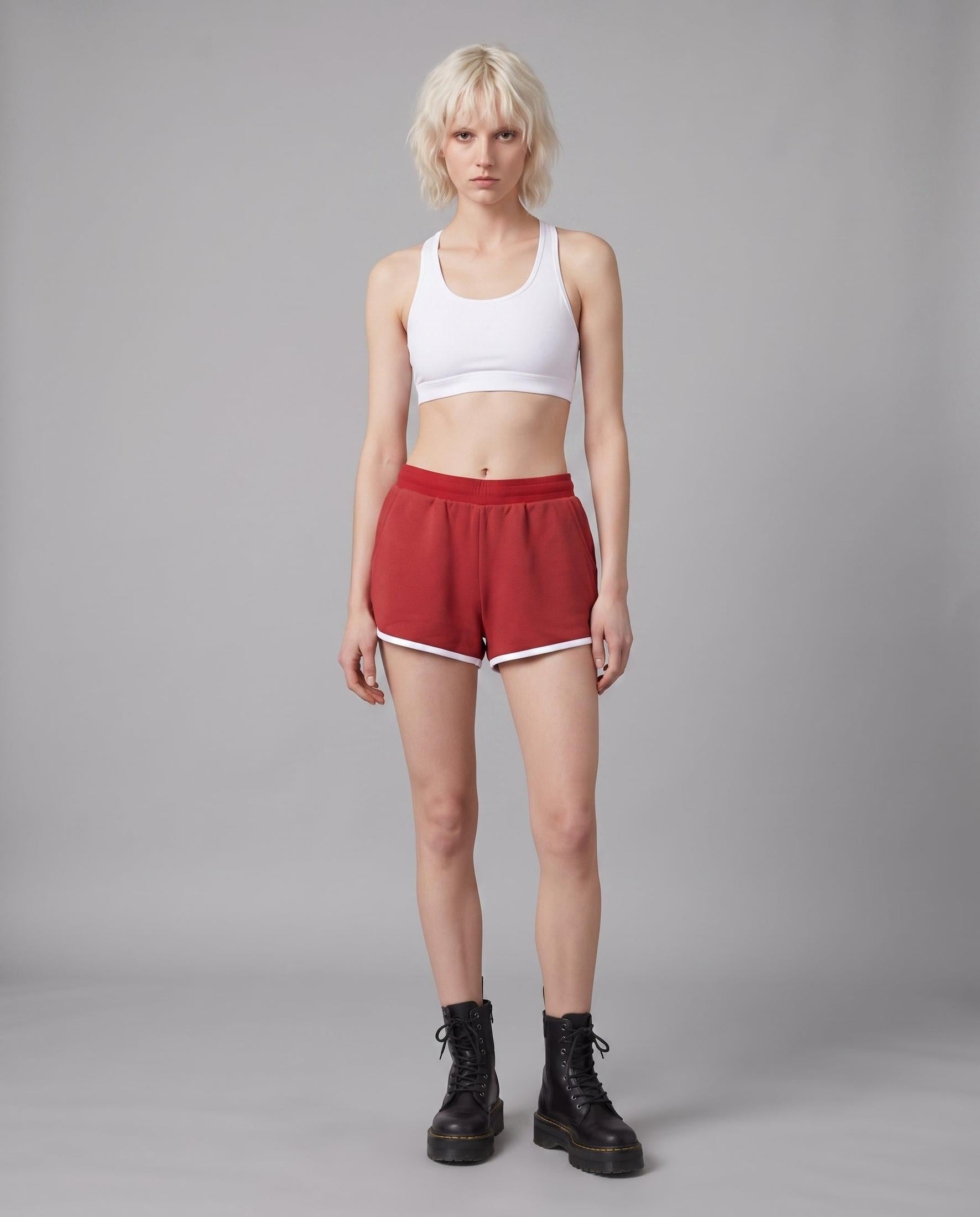 Model wearing red casual stretch shorts with white hem trim and natural waist fit