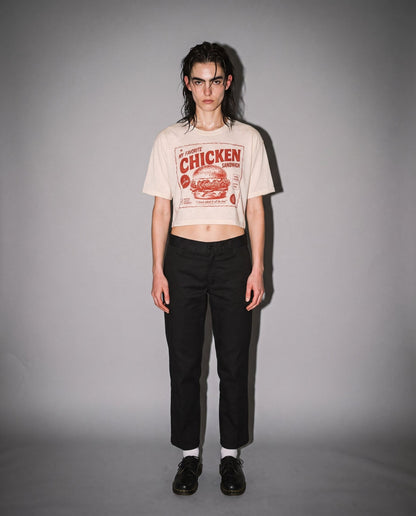 Woman wearing warm cream distressed chicken sandwich graphic crop tee with black pants