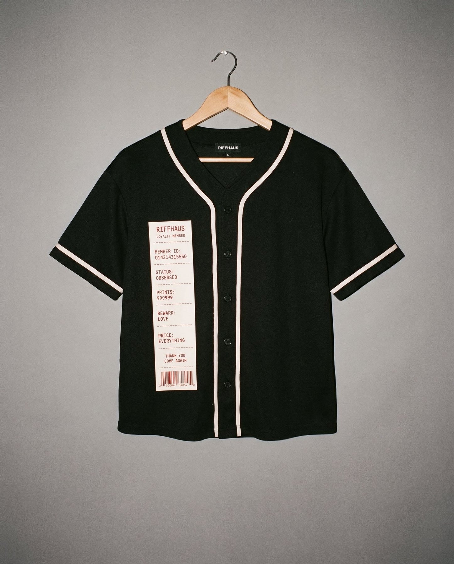 Black V-neck short sleeve button up shirt with beige piping and novelty receipt chest tag