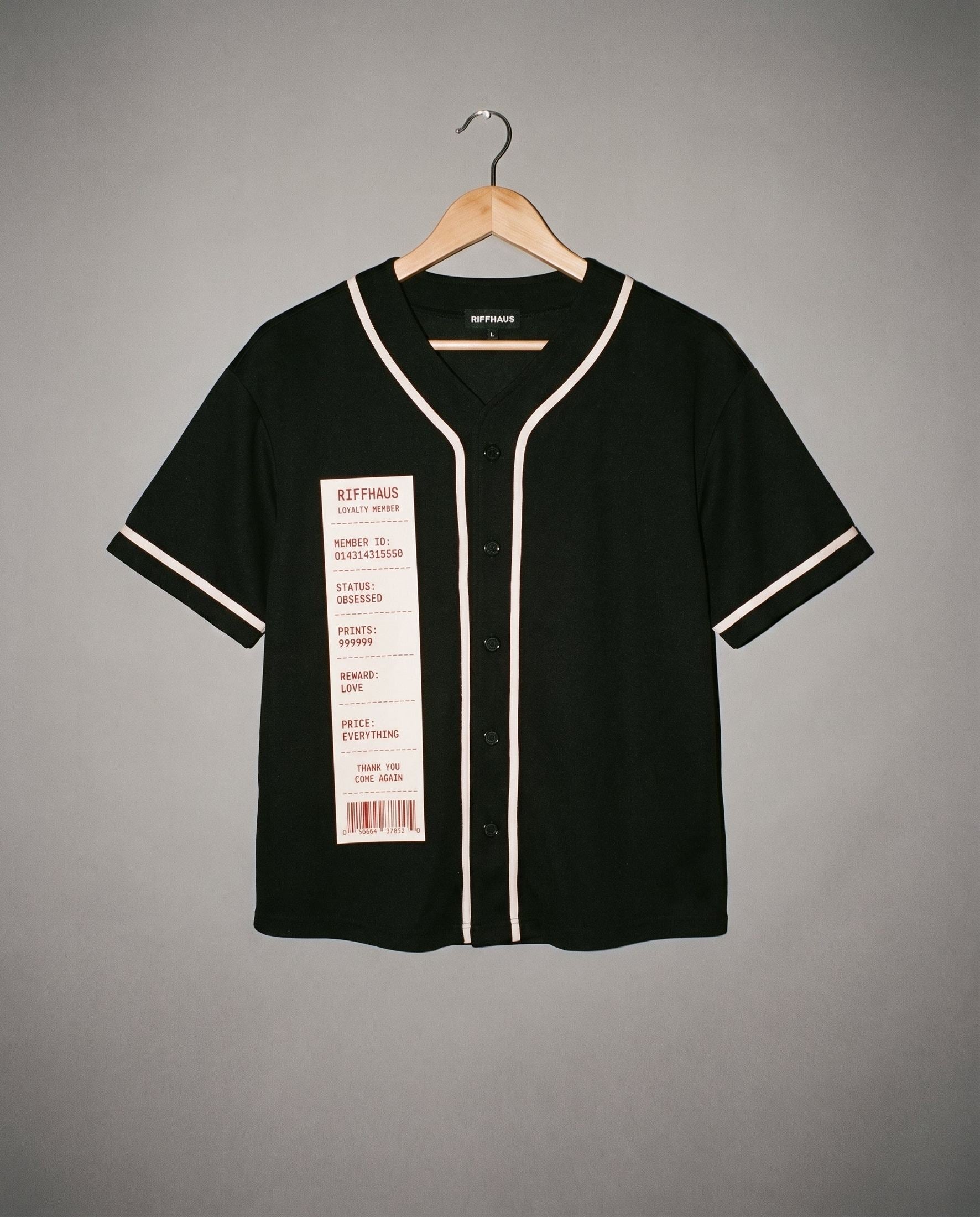 Black V-neck short sleeve button up shirt with beige piping and novelty receipt chest tag