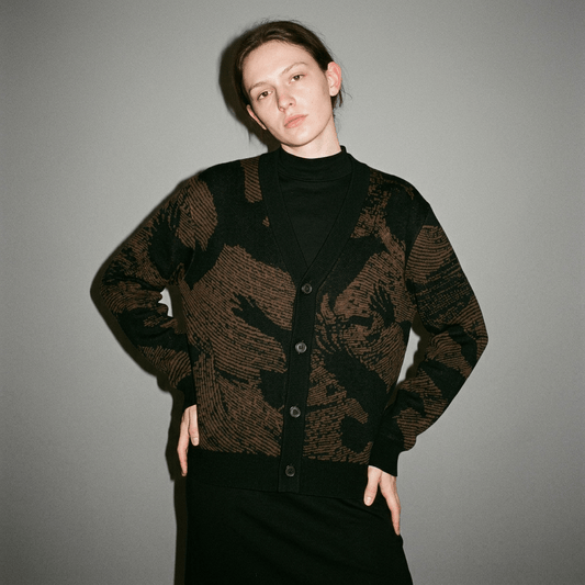 Front view of buttoned earth tone cardigan with graphic crow print detail