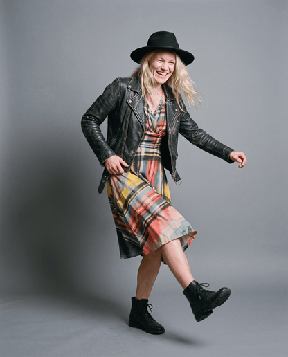 Plaid midi dress styled with black leather biker jacket and wide-brim hat