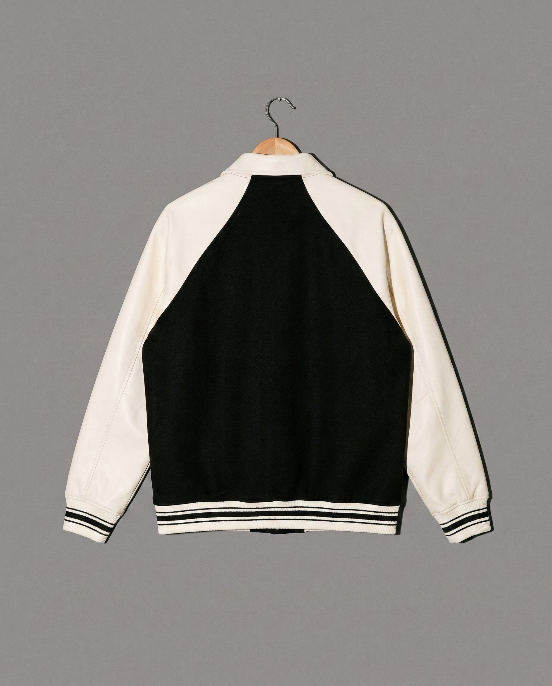 Black and cream varsity jacket back view with striped hem