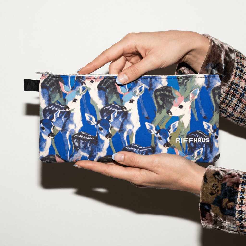 Teal and white fawn print zippered pencil case held in hands