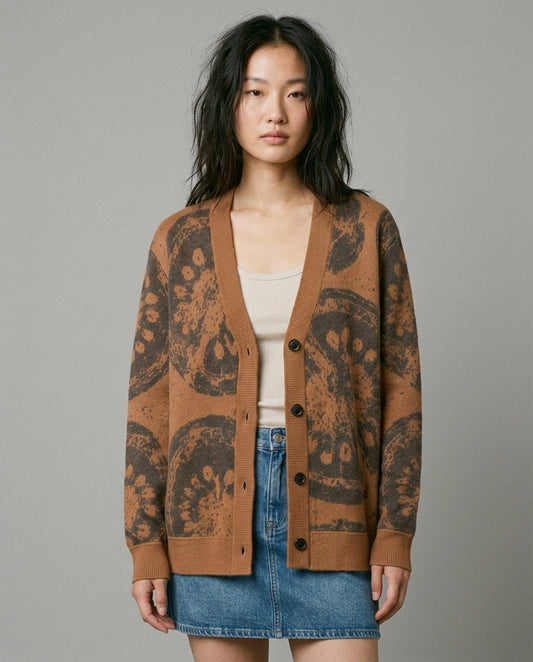 Woman wearing oversized V-neck tomato jacquard cardigan over denim skirt front fit