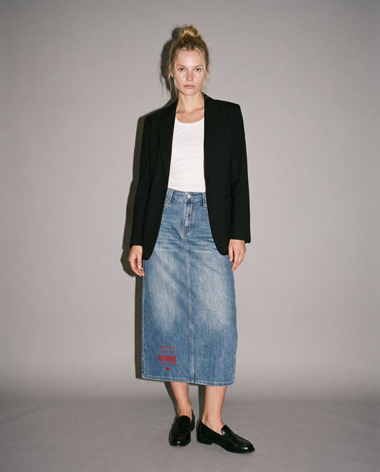 Model wearing fitted blue denim midi skirt with declarative red text print