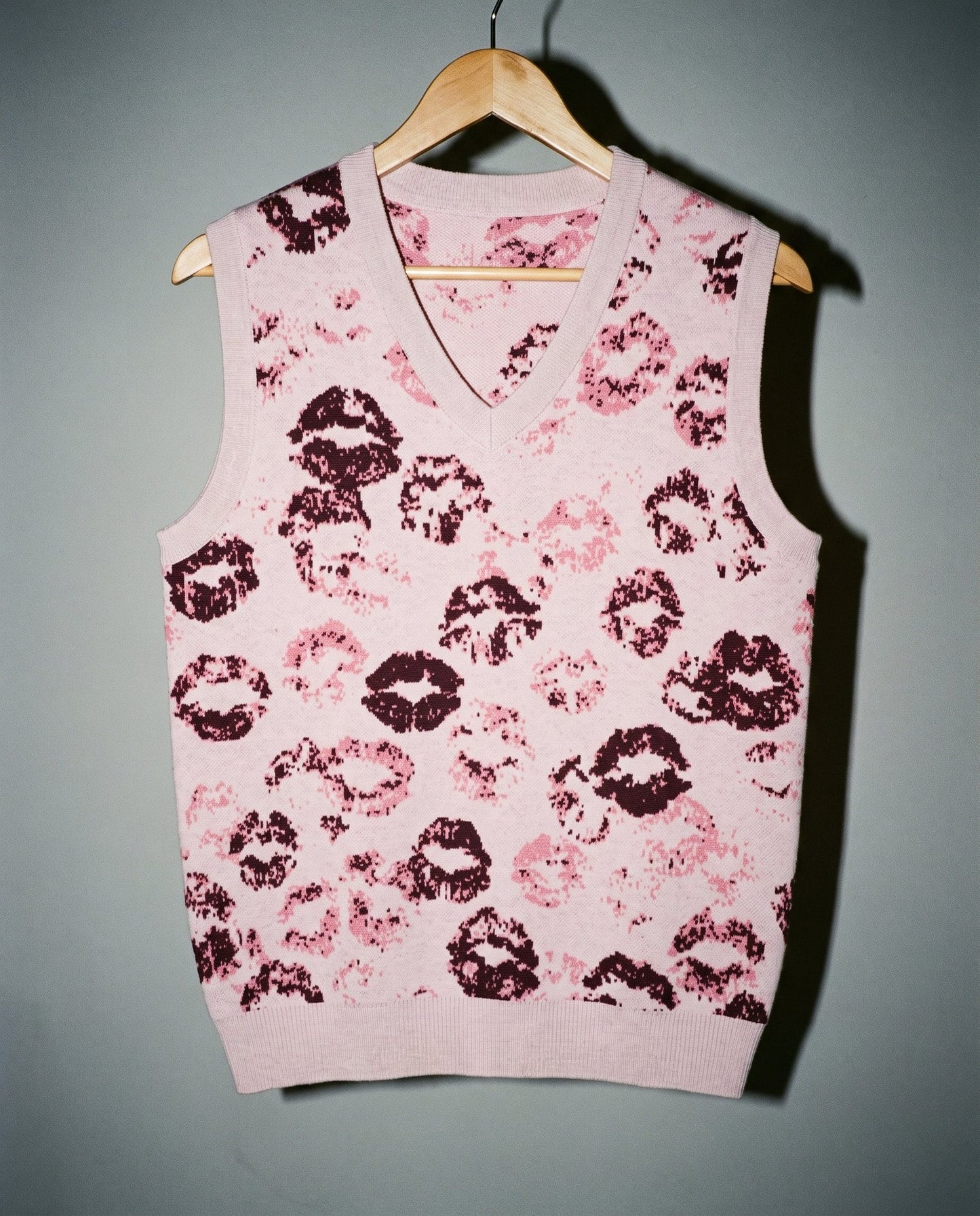 Light pink V-neck vest featuring graphic overlapping kiss marks