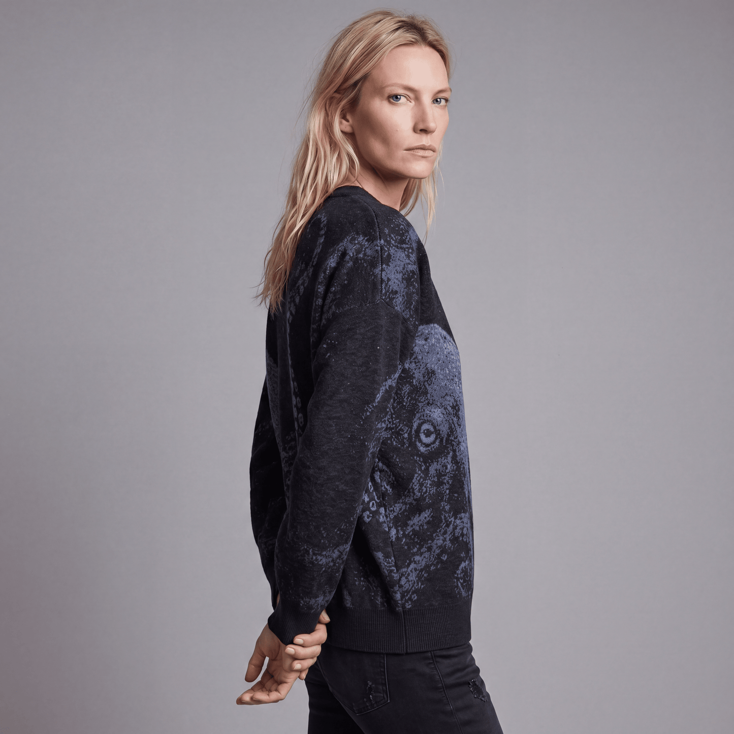 Side view of woman wearing Riffhaus KRAKEN dark heathered knit sweater showing octopus tentacle detail