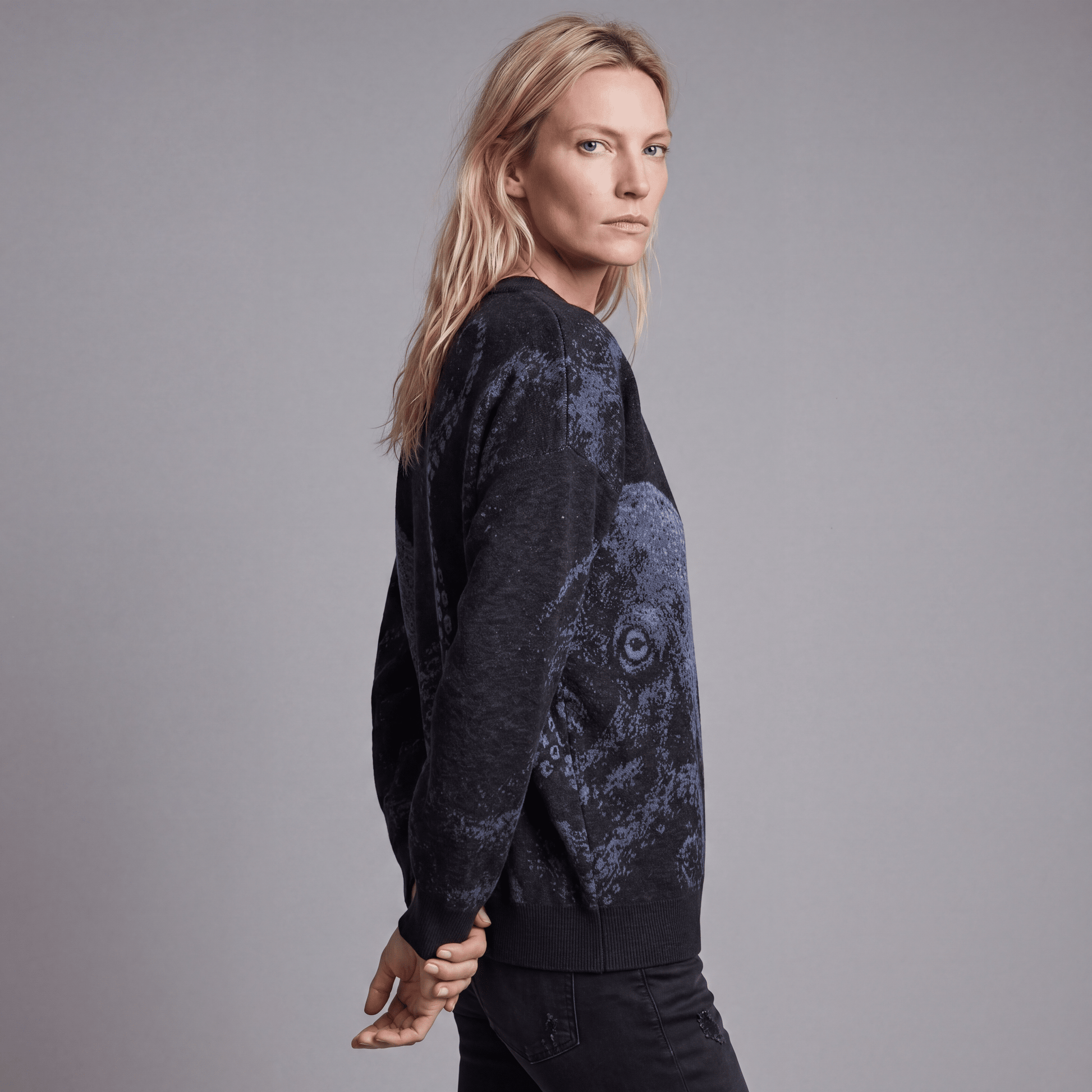 Side view of woman wearing Riffhaus KRAKEN dark heathered knit sweater showing octopus tentacle detail