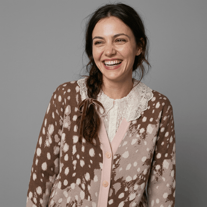 Laughter shot of model in spotted cardigan and lace blouse neckline