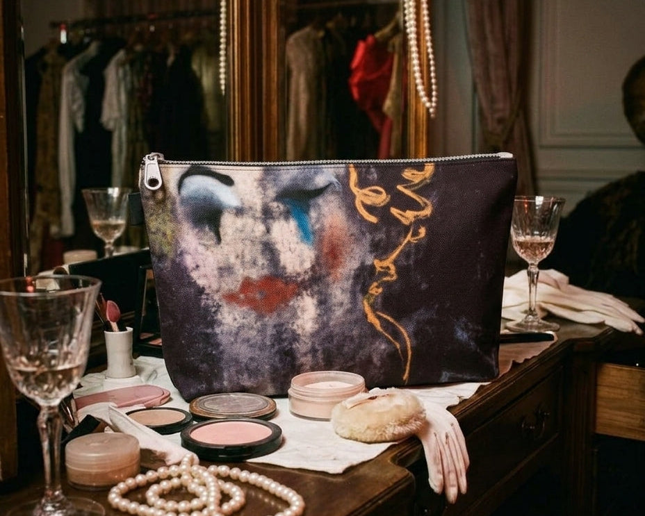 Artistic makeup bag with blue tear design on vanity surrounded by vintage props