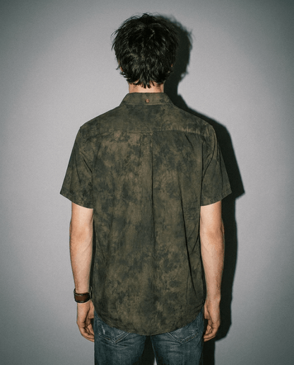 Back view of MILDEW relaxed fit short sleeve button up shirt with earth tone foliage pattern