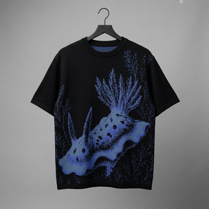 Black Oxis nudibranch short sleeve shirt hanging on hanger showing knit texture