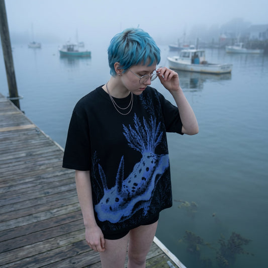 Black ghostly nudibranch knit t-shirt worn on foggy harbor dock