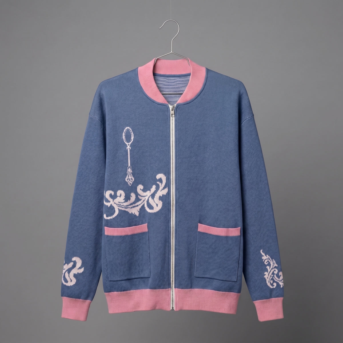 Front view of blue knit bomber jacket showing silver zipper, pockets, and ornate spoon jacquard motif