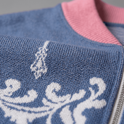 Close-up of blue knit bomber jacket fabric texture and white jacquard weave near collar