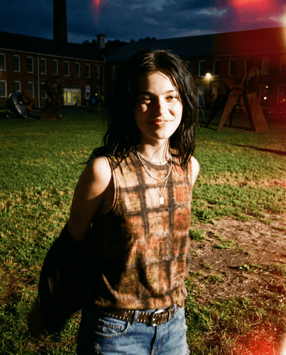 Woman wearing Riffhaus PLOT earthy grid tank top outdoors at dusk