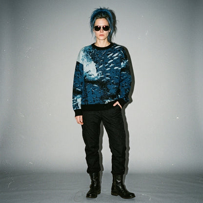 Full-length shot of model wearing Riffhaus Sardine School knit sweater with abstract fish design