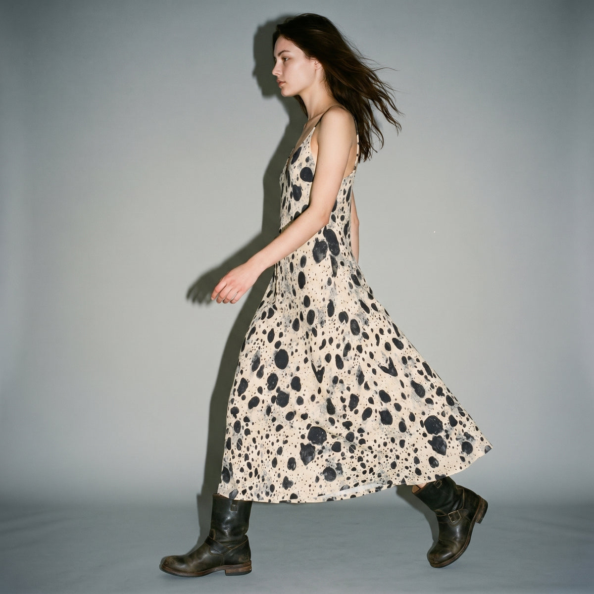 Side motion shot showing A-line drape of cream speckled long dress