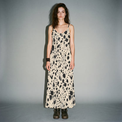Model wearing cream speckled long sleeveless dress with side pockets