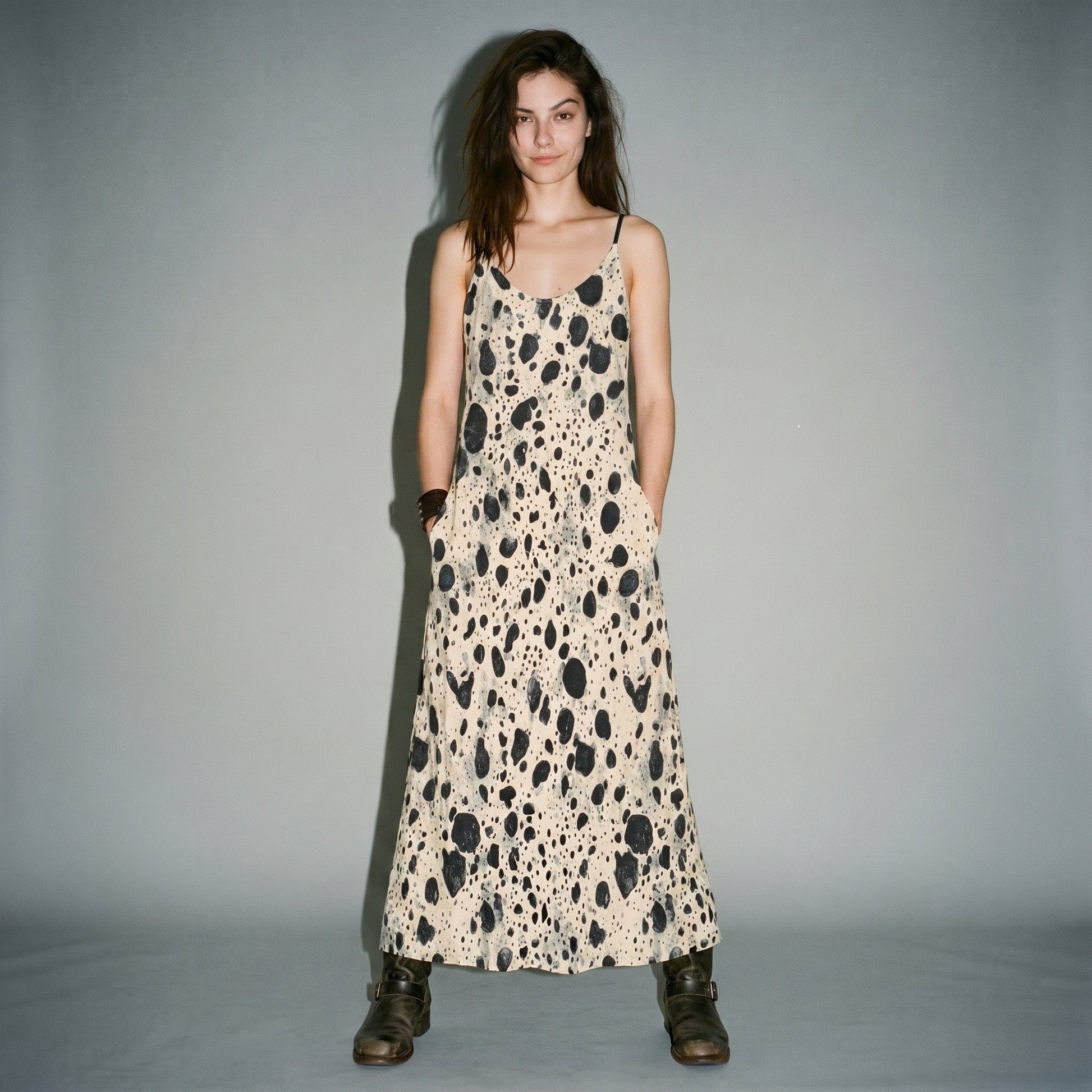 Front view of model in cream speckled long dress with hand in pocket