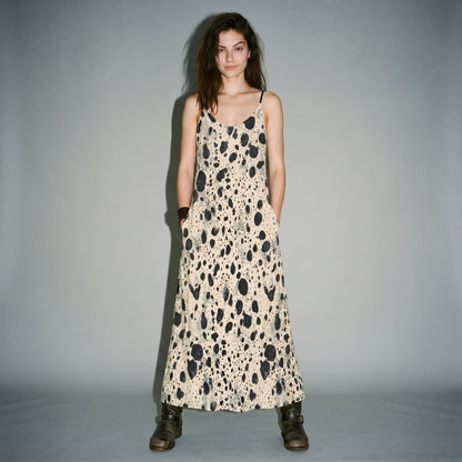 Front view of model in cream speckled long dress with hand in pocket