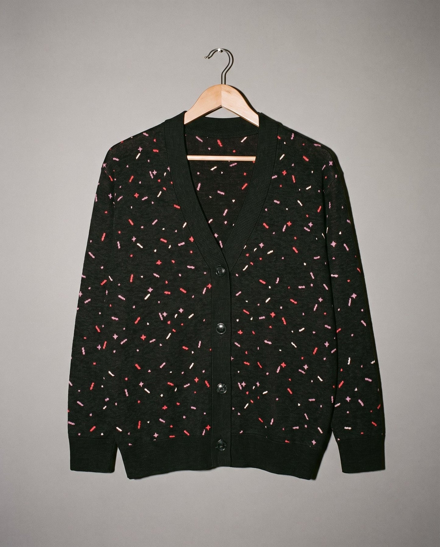 Black unisex knit cardigan with pink red and white confetti flecks