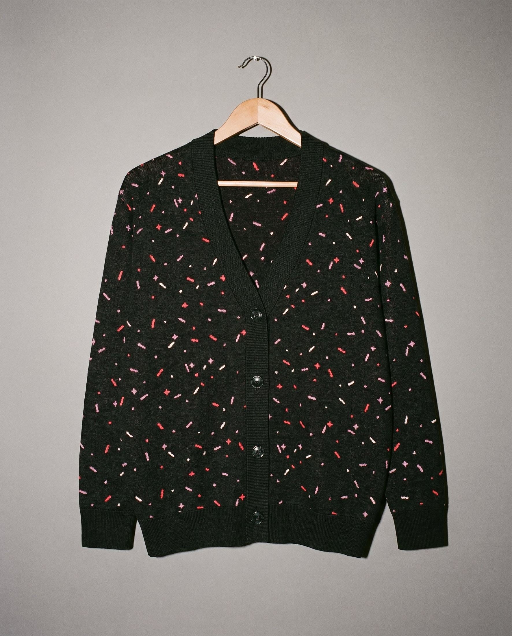 Black unisex knit cardigan with pink red and white confetti flecks