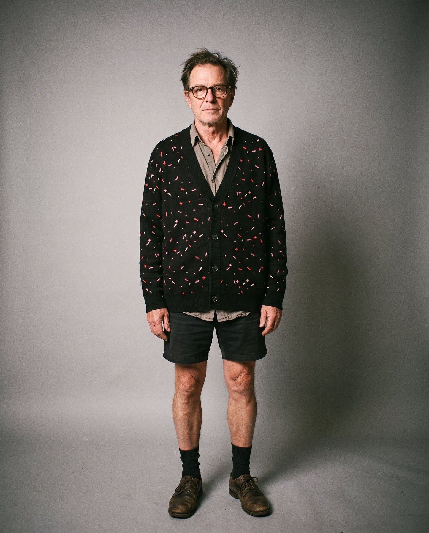 Man wearing relaxed fit black sprinkle print cardigan over shirt