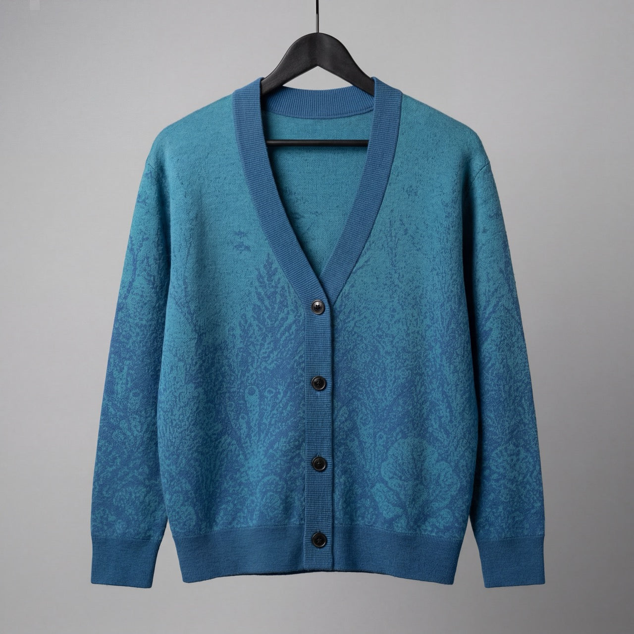 Front view blue knit cardigan with dark brown buttons and abstract pattern