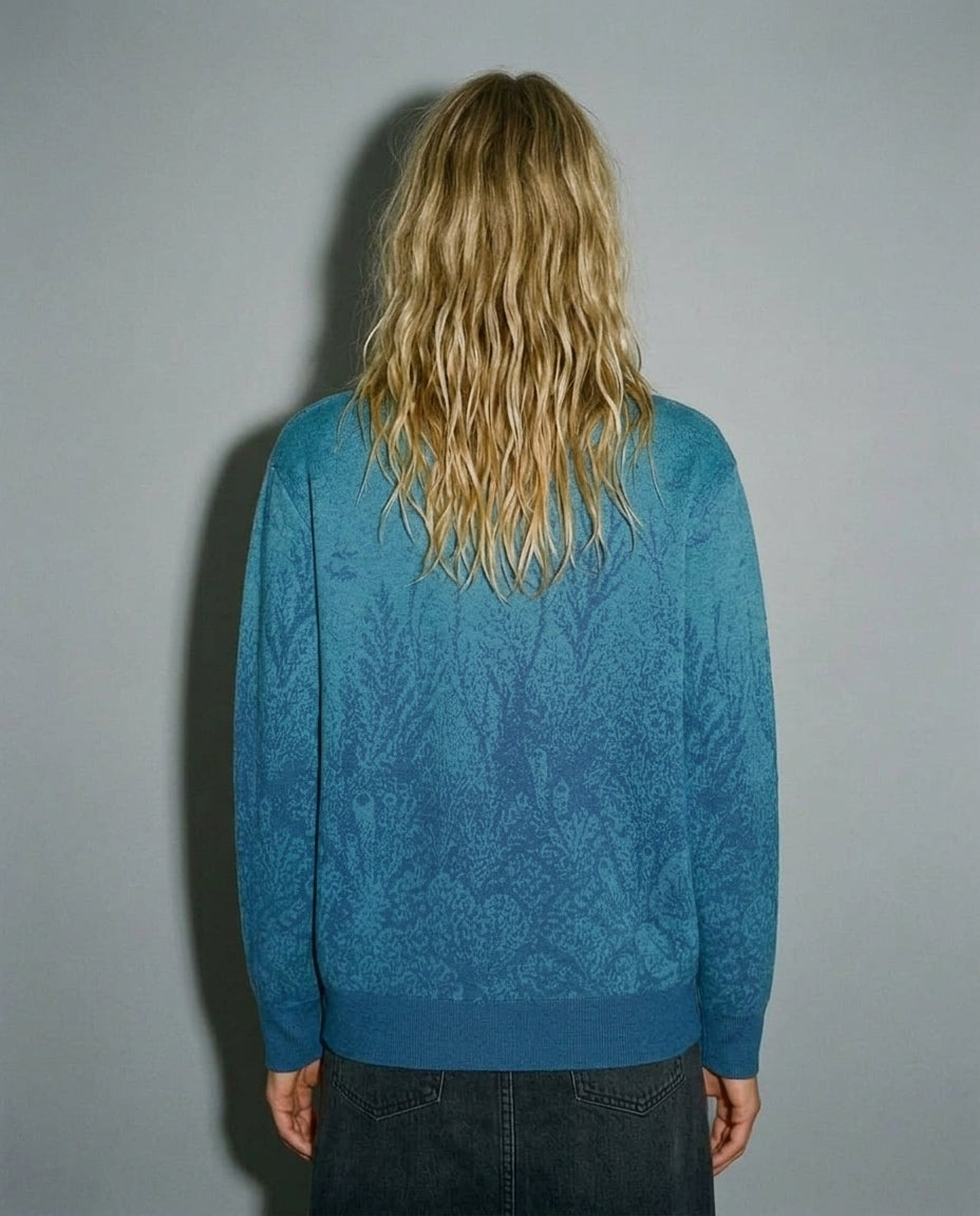 Rear view of blue cardigan featuring submerged coral knit design