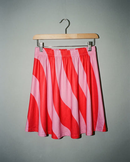 SWHIRL A-line pink and red swirl skirt on hanger showing smooth stretch fabric