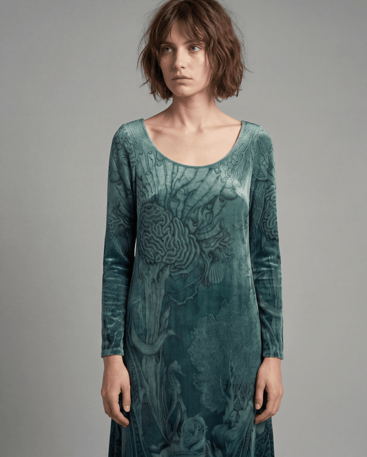 Model wearing fitted teal velvet long-sleeve dress with ocean life print