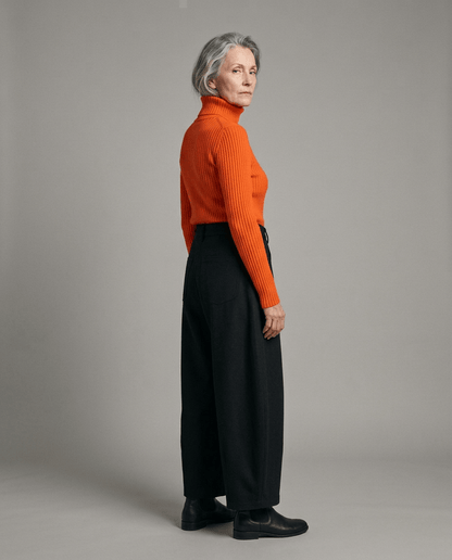 Side profile of black voluminous cropped pants ending above ankle