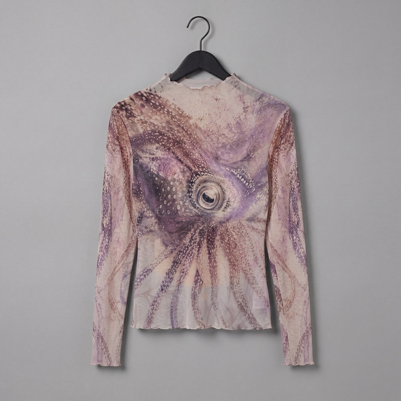 Rear angle of The Teacher high neck top featuring central octopus eye motif