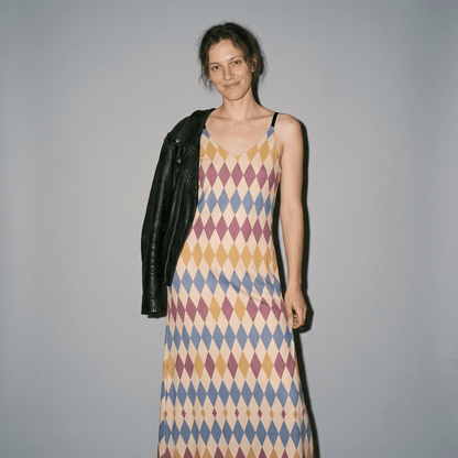 Patterned long slip dress styled with black leather jacket for layering