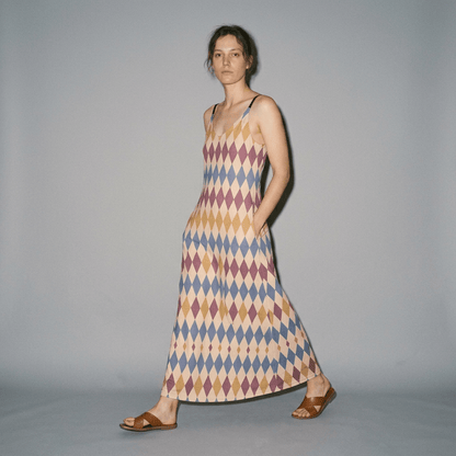 Model walking in diamond print slip dress demonstrating side pockets and regular fit
