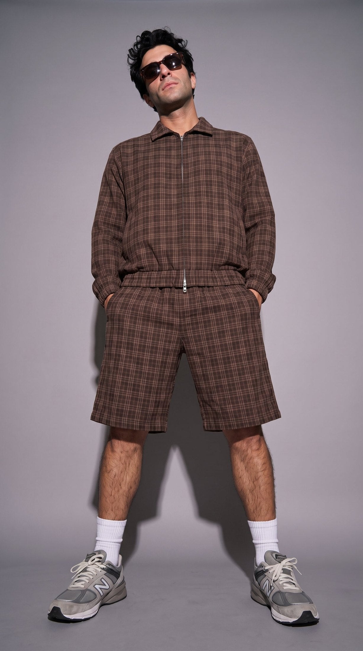 Woman wearing brown plaid oversized cropped jacket with matching shorts